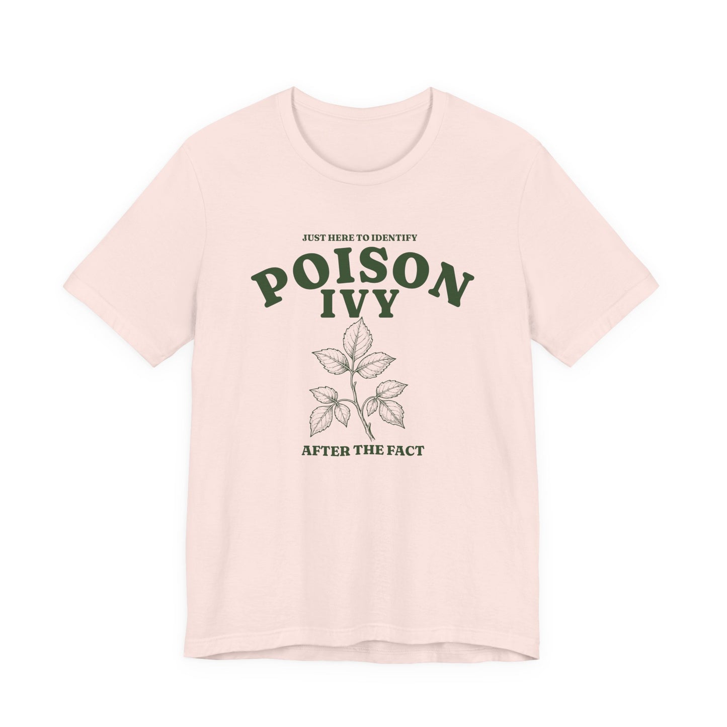 Soft pink adult T-shirt featuring retro green lettering, a botanical poison ivy graphic, and a sarcastic camping phrase.