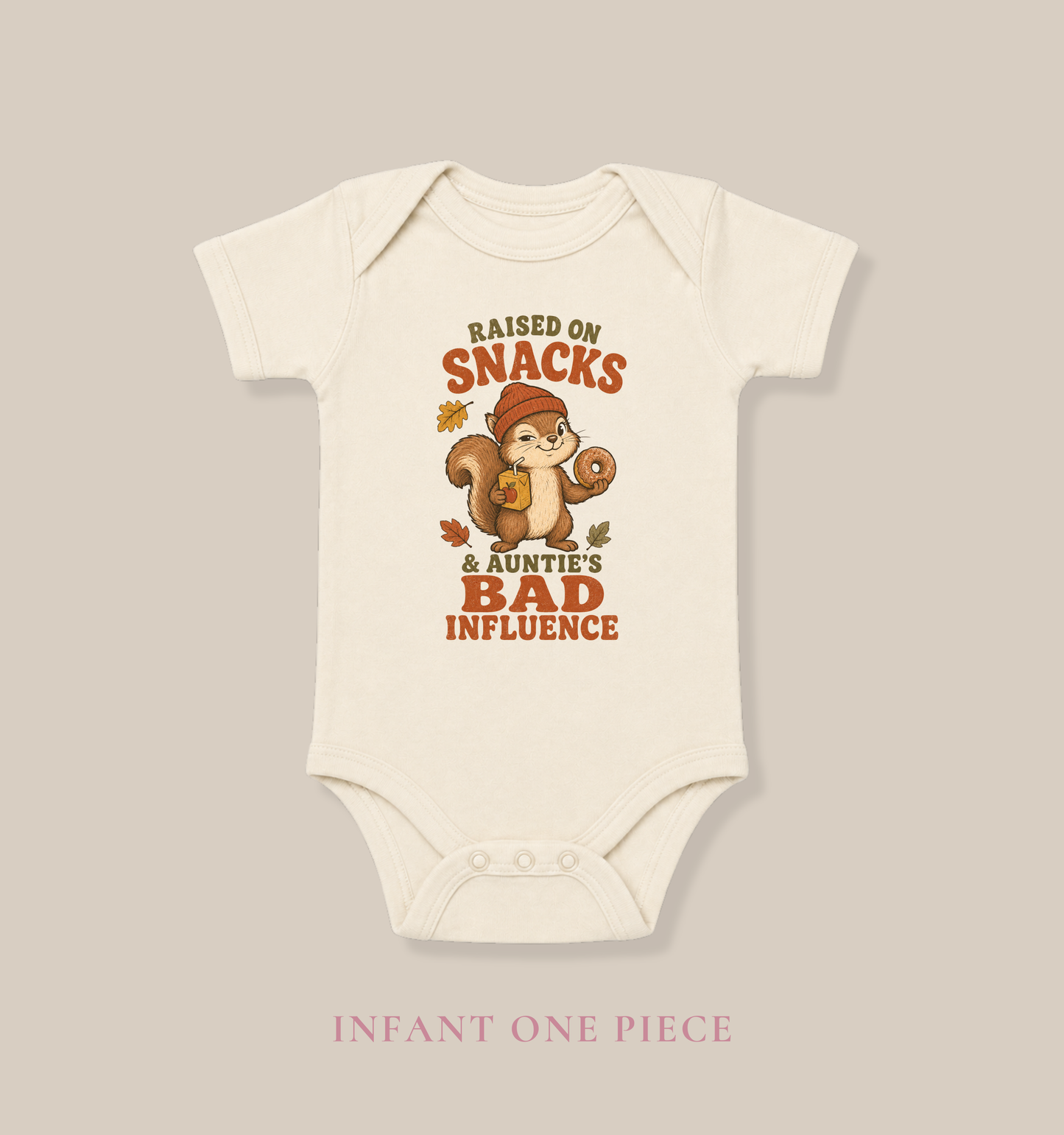 Natural baby one piece featuring a squirrel holding a donut and juice box, autumn leaves, and the phrase “Raised on Snacks & Auntie’s Bad Influence.”