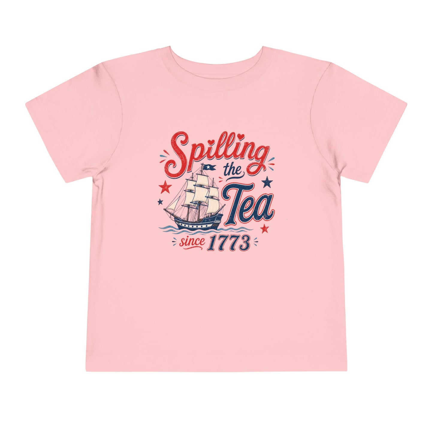 Light pink toddler t-shirt featuring a vintage patriotic “Spilling the Tea Since 1773” graphic with a colonial sailing ship, distressed red and blue lettering, and festive Fourth of July stars and accents