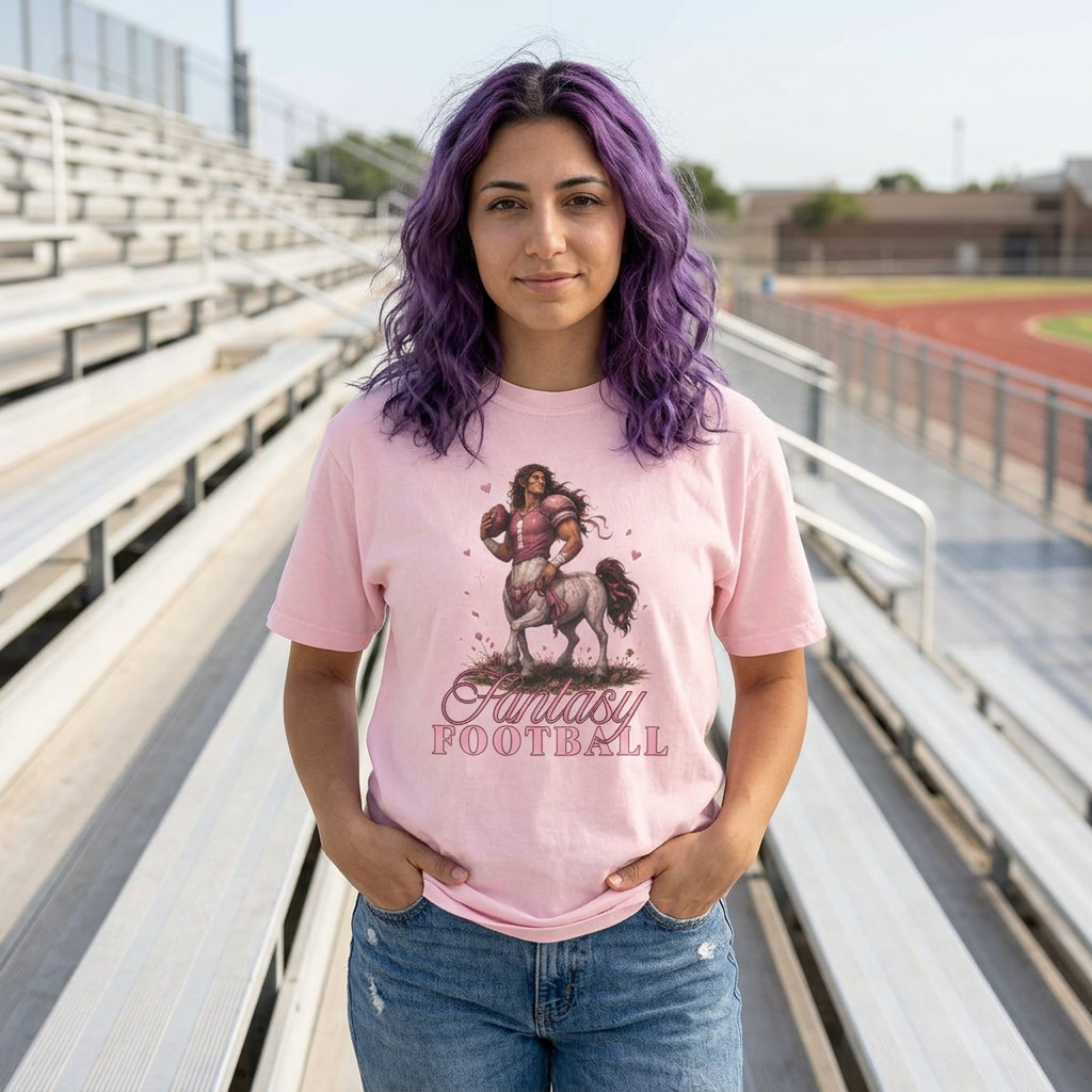woman modeling a pink romantasy fantasy football graphic tee featuring a feminine centaur football player design in stadium bleachers