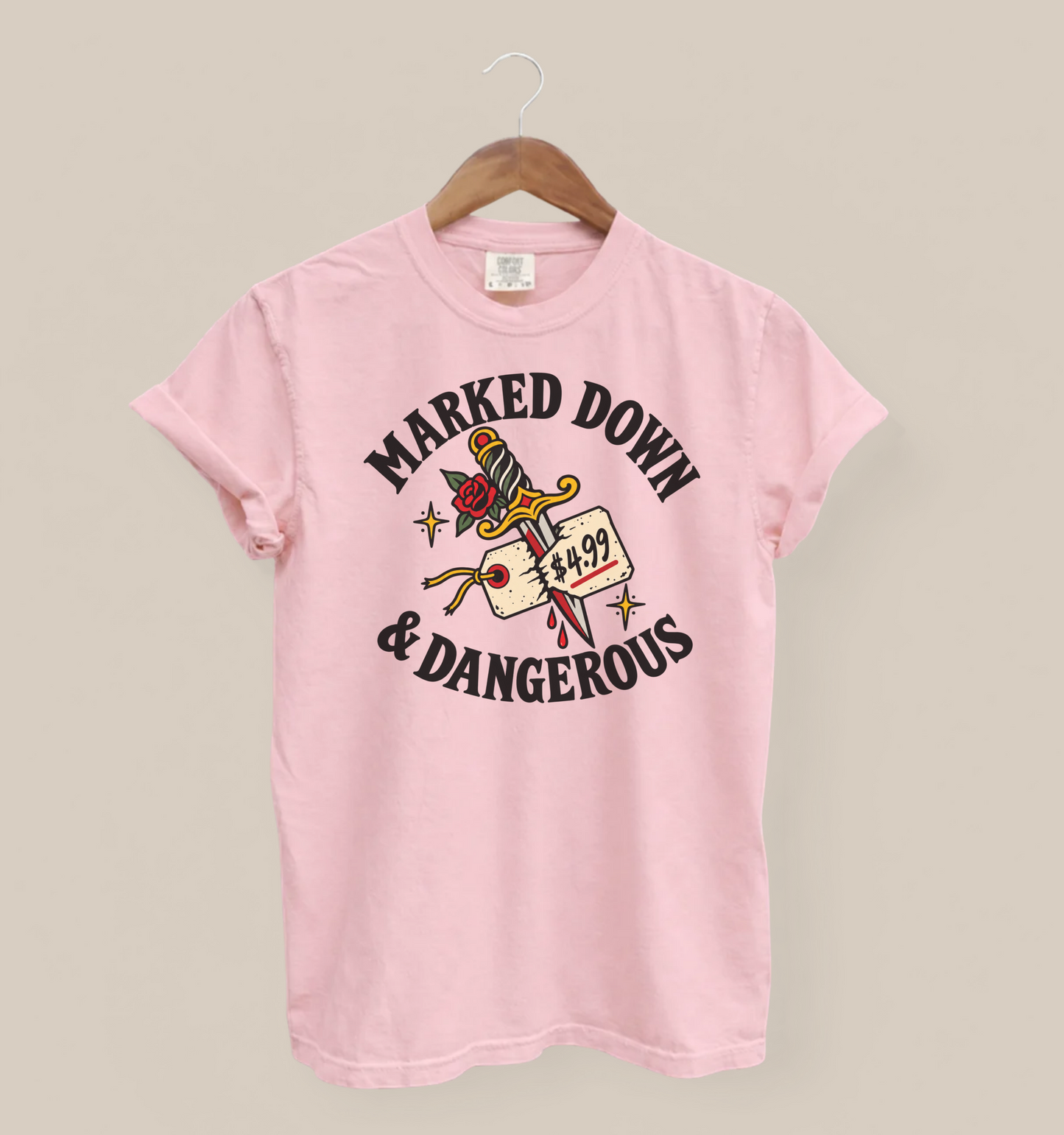 Marked Down & Dangerous design on a Blossom Comfort Colors tee, hanging against a warm neutral background.