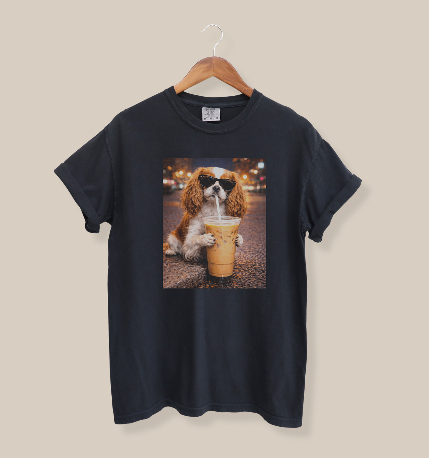 black graphic tee featuring a cavalier king charles spaniel in sunglasses holding an iced coffee on a city street at night