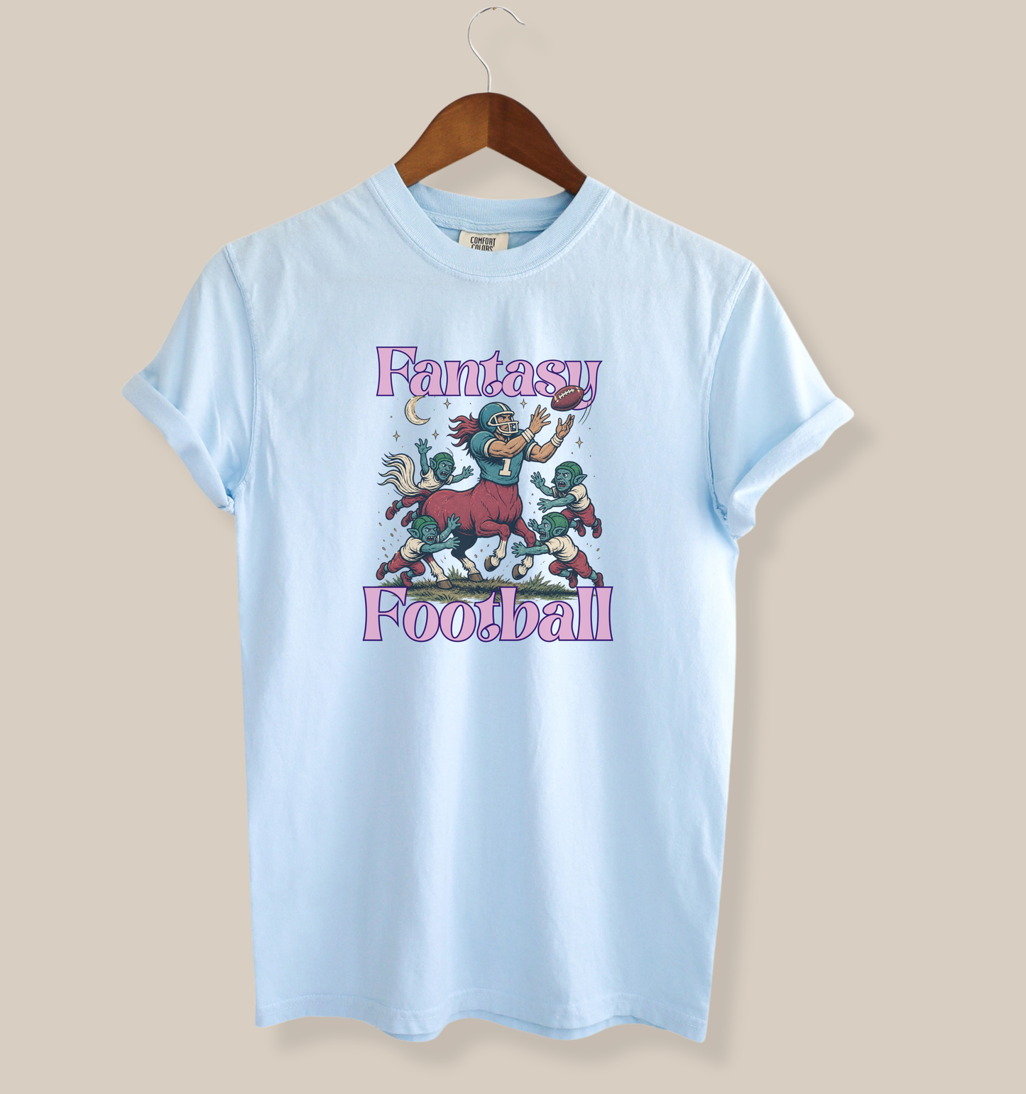 Chambray blue graphic tee featuring a fantasy football centaur catching a football while goblin creatures surround him in a whimsical fantasy sports design
