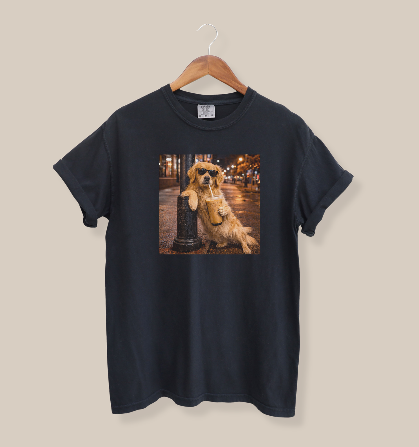 black graphic t-shirt featuring a golden retriever in sunglasses holding iced coffee on a city street at night