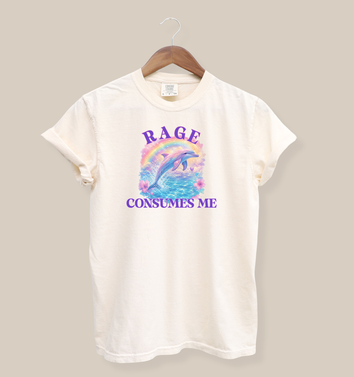 ivory graphic tee featuring a colorful dolphin jumping over a rainbow with pastel ocean design and the phrase rage consumes me