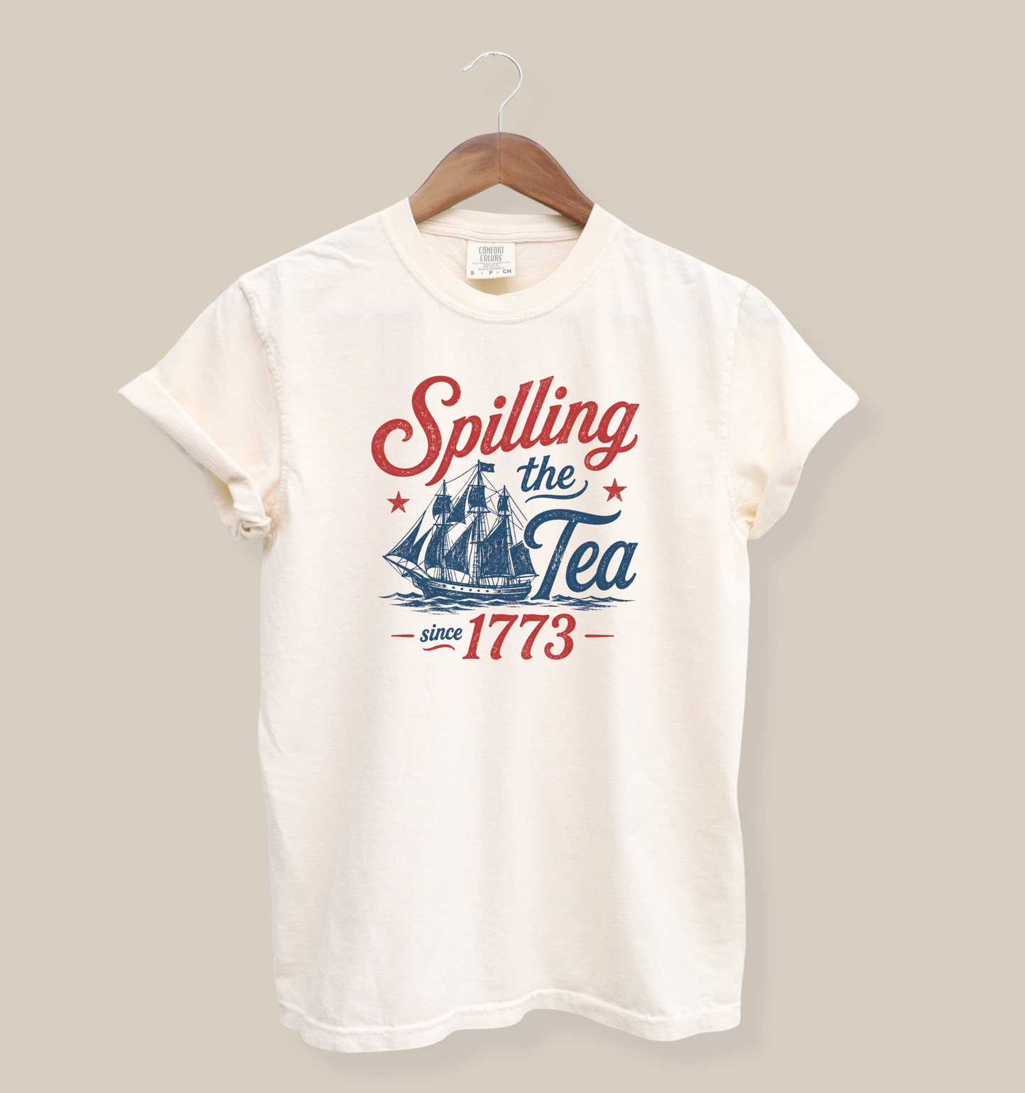 ivory patriotic fourth of july graphic tee featuring spilling the tea since 1773 slogan with colonial ship artwork in red and blue vintage style