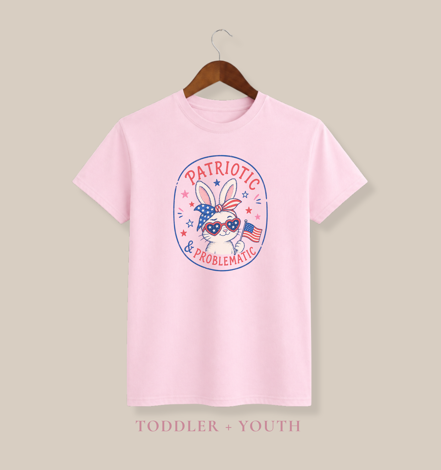 toddler fourth of july graphic tee in soft pink featuring a cute patriotic bunny wearing american flag sunglasses and bandana with patriotic and problematic slogan